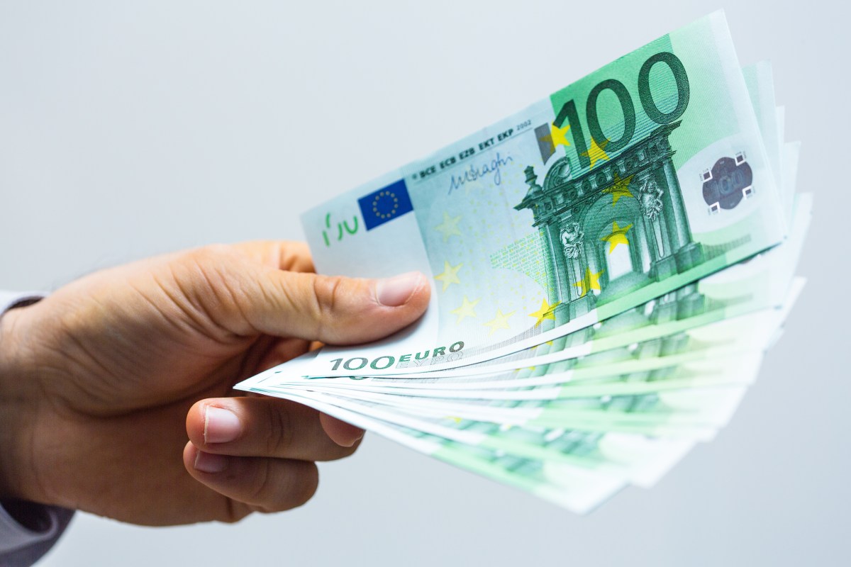 Eine Person hält mehrere 100-Euro-Scheine in der Hand.