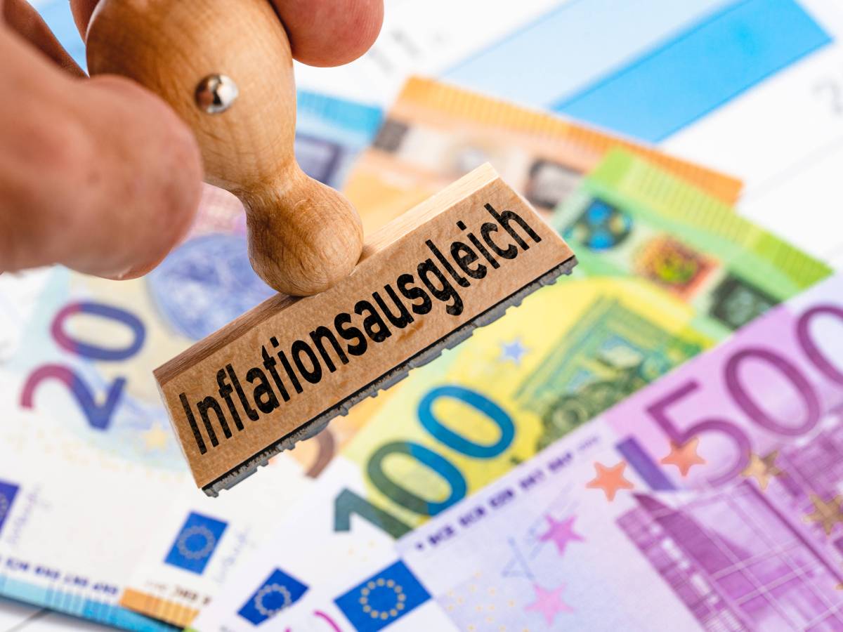 Auf einem Stempel steht das Wort "Inflationsausgleich". Darunter liegen Geldscheine.