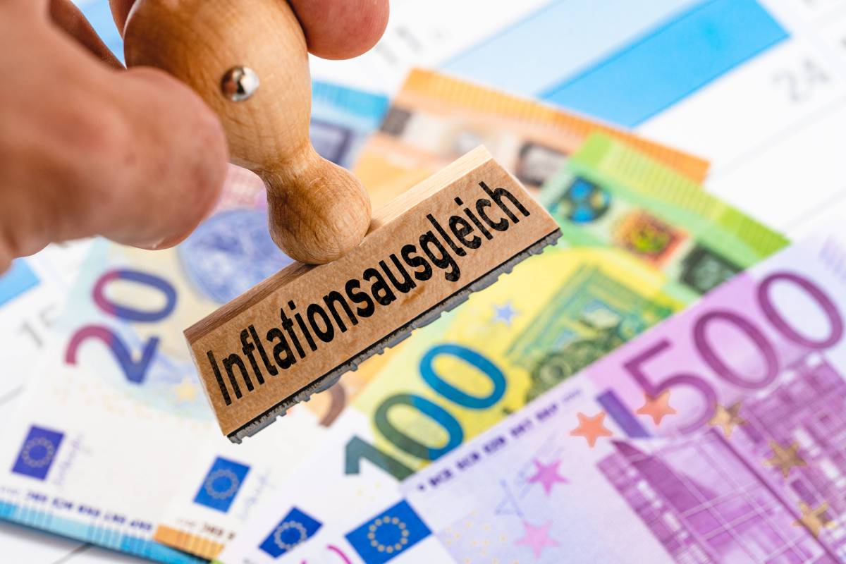 Auf einem Stempel steht das Wort "Inflationsausgleich". Darunter liegen Geldscheine.