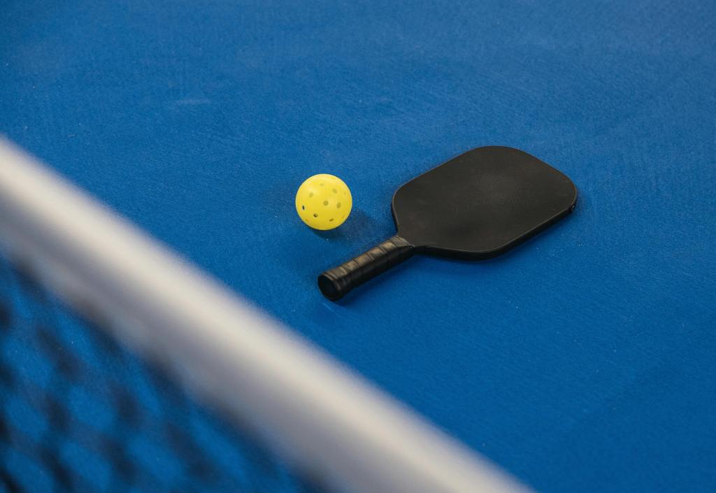 Pickleballschläger und Ball auf blauem Badmintonfeld