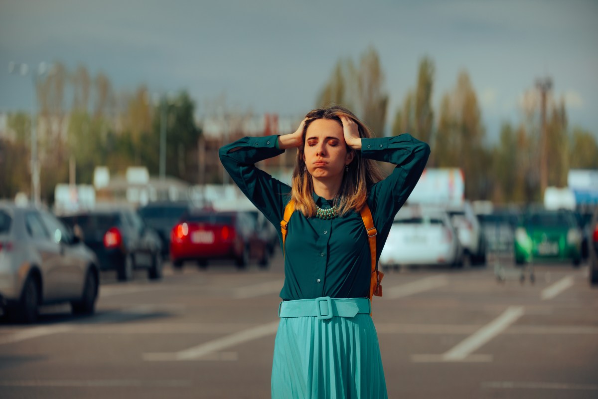 Frau steht auf Parkplatz und sucht Auto