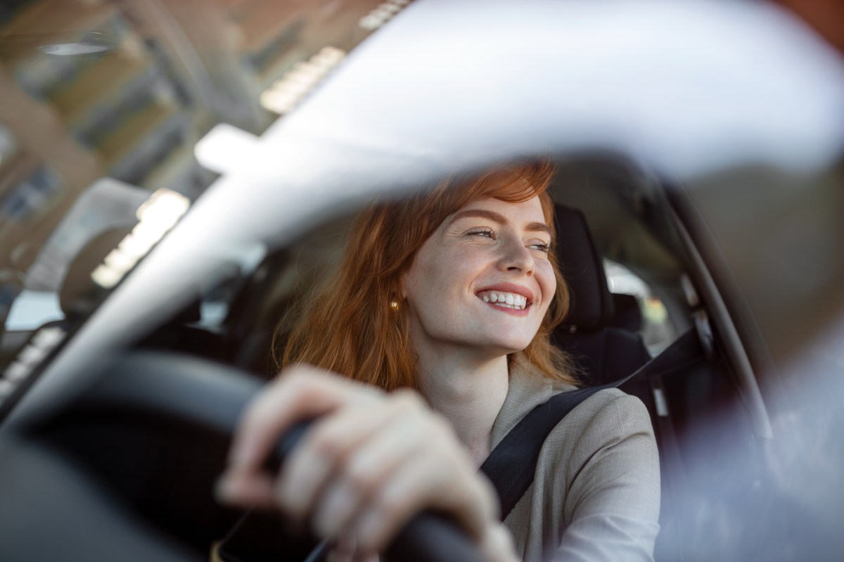 Frau sitzt im Auto und lacht