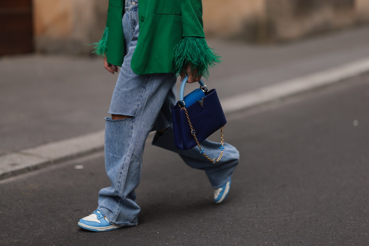 Frau geht in Jeans über Straße