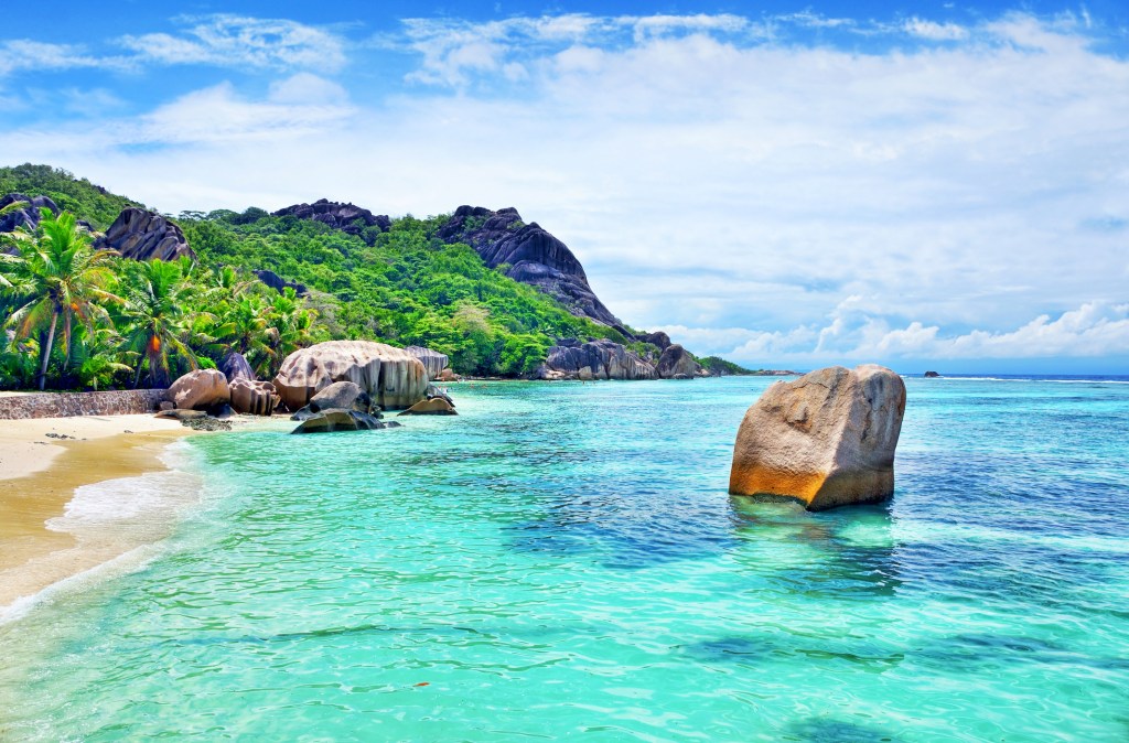 Strand auf den Seychellen mit Bergen im Hintergrund