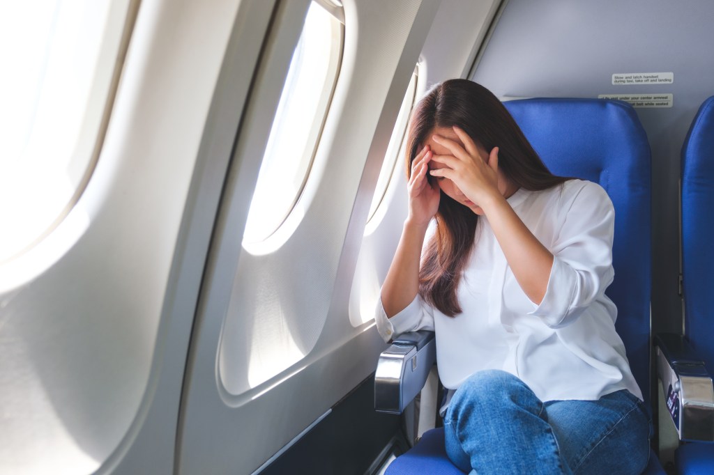 Frau mit Jetlag im Flugzeug