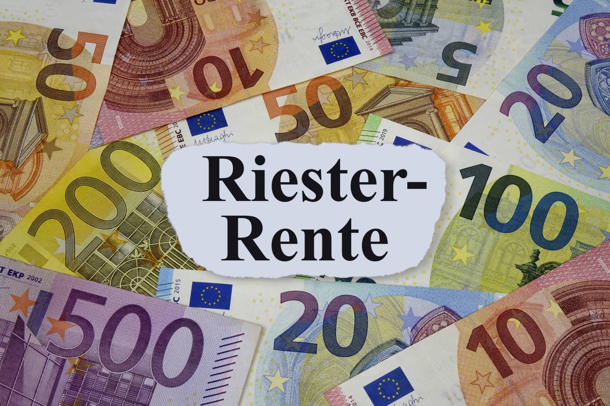 Auf einem weißen Zettel steht das Wort "Riester-Rente". Darunter liegen Geldscheine.