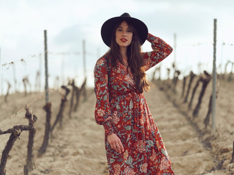 Frau in Herbstkleid auf Feld