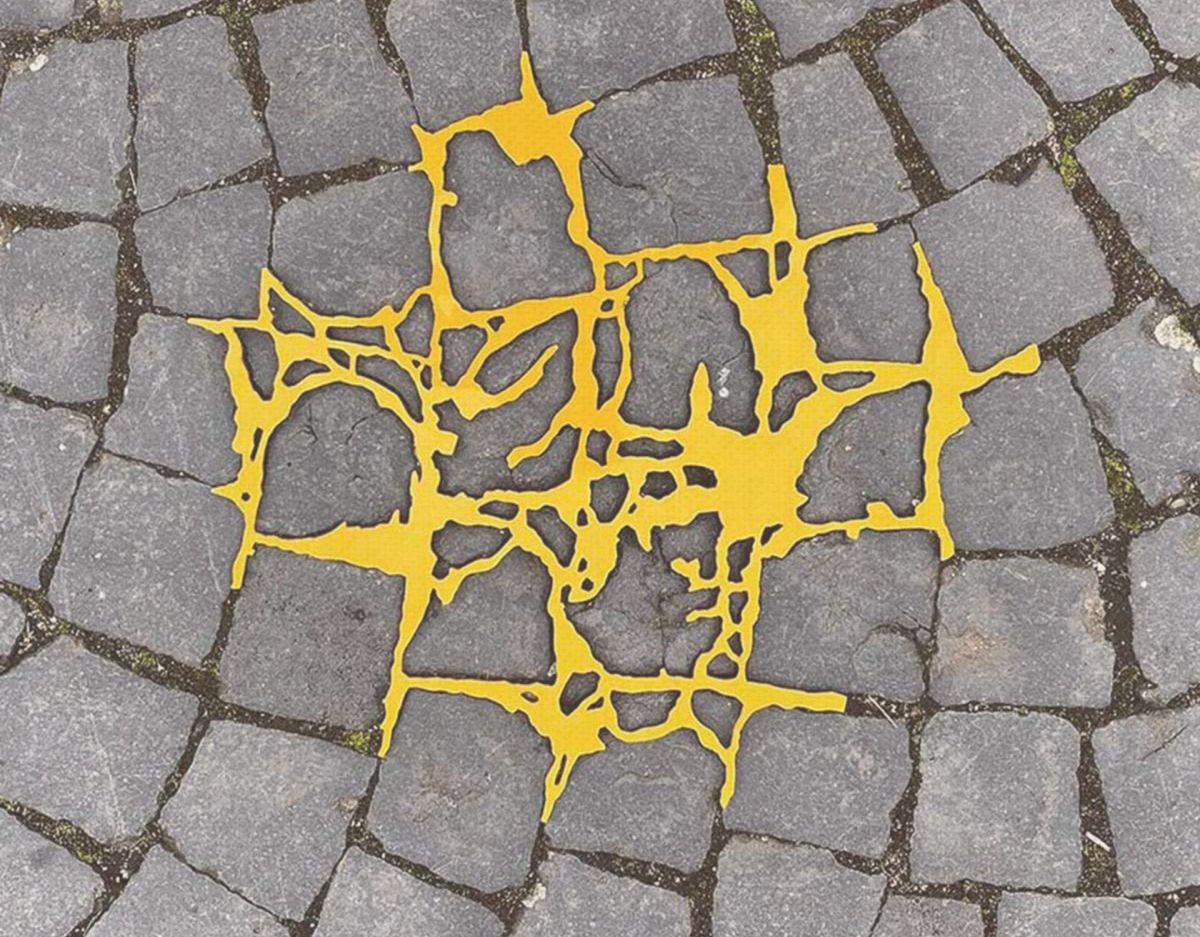 Gelber Kunststoff füllt Risse auf Kopfsteinpflaster, Kintsugi Art