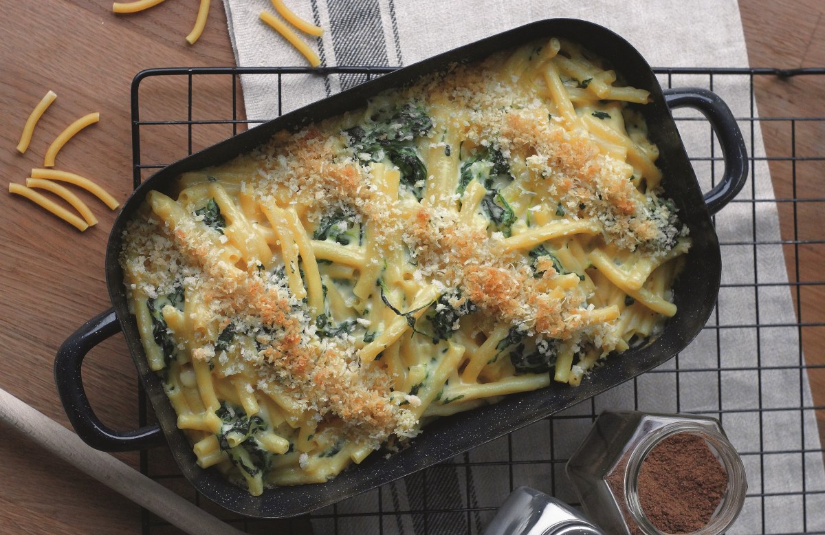 Mac'n'Cheese mit Spinat in einer schwarzen Auflaufform auf einem Kuchengitter.