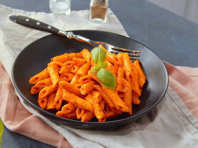 One-Pot-Penne mit Tomate-Mozzarella auf einem Teller.