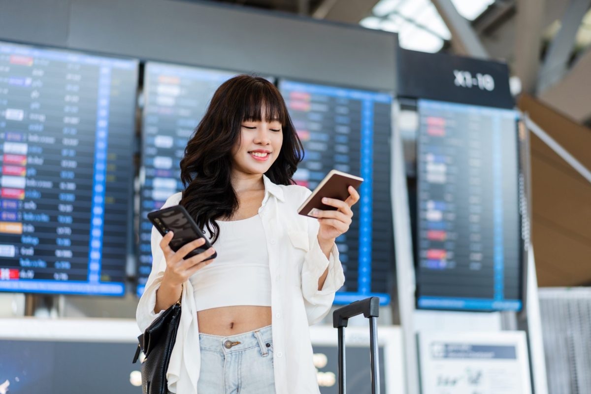 Frau am Flughafen mit Reisepass