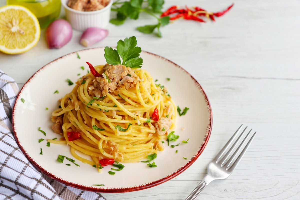 Teller mit Spaghetti mit Thunfisch und Gabel daneben