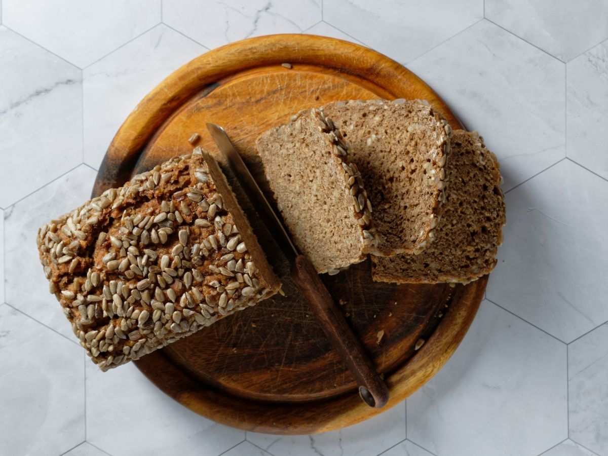 Ein aufgeschnittenes 5-Minuten-Brot liegt auf einem Bett. Einige Brotscheiben sind zu sehen, daneben liegt ein Messer.