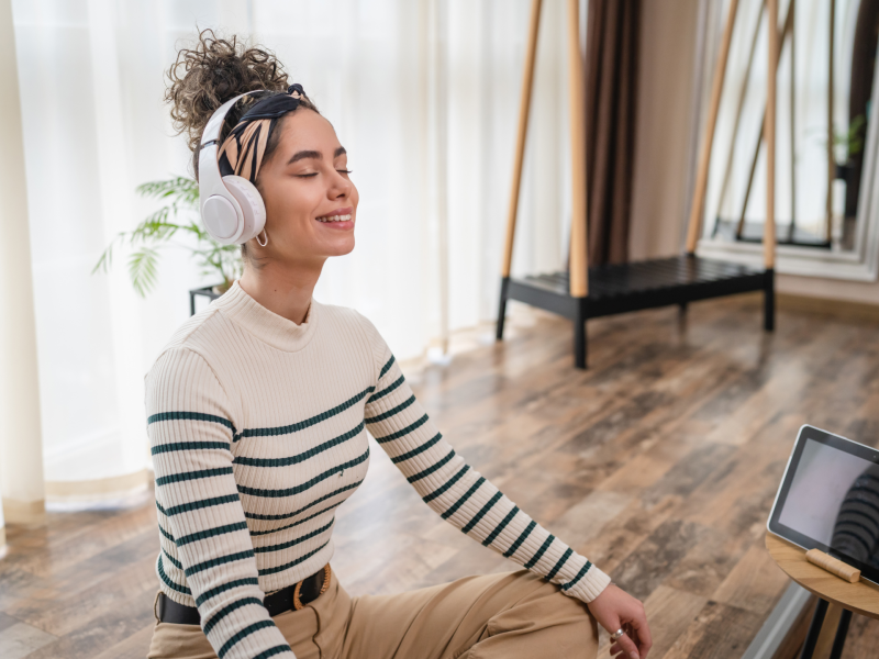 Frau mit Kopfhörern geführte Meditation