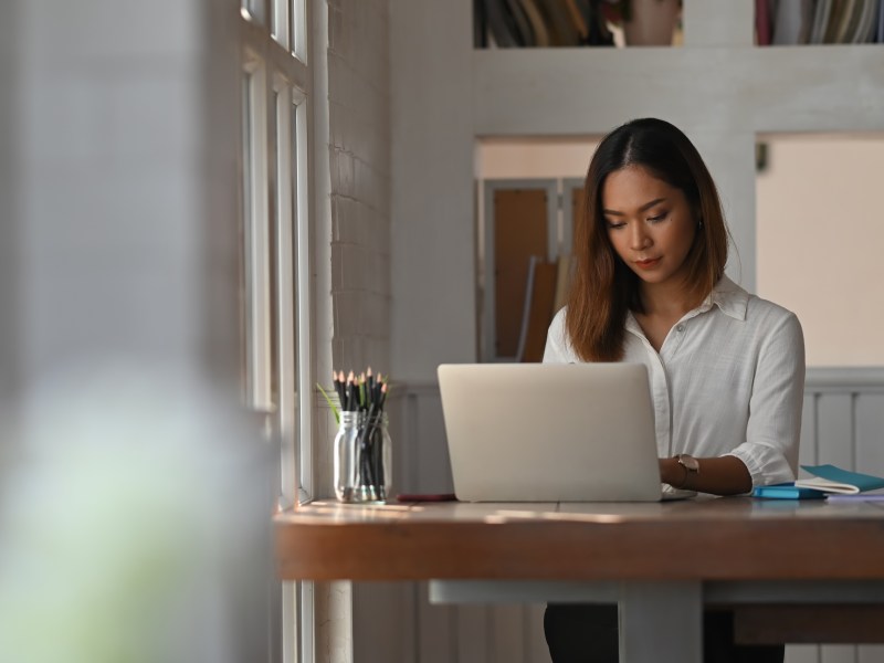 Geschäftsfrau arbeitet im Homeoffice mit Laptop-Computer.