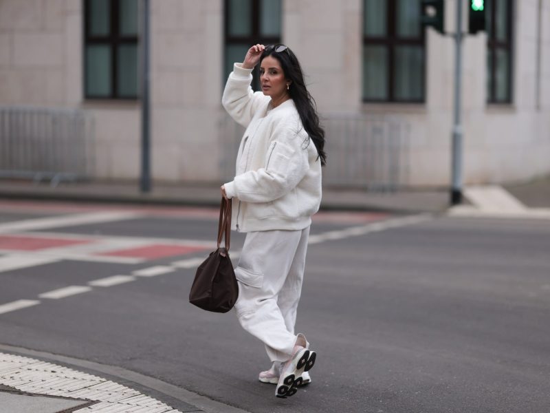 Frau im weißen Outfit mit Sneakern