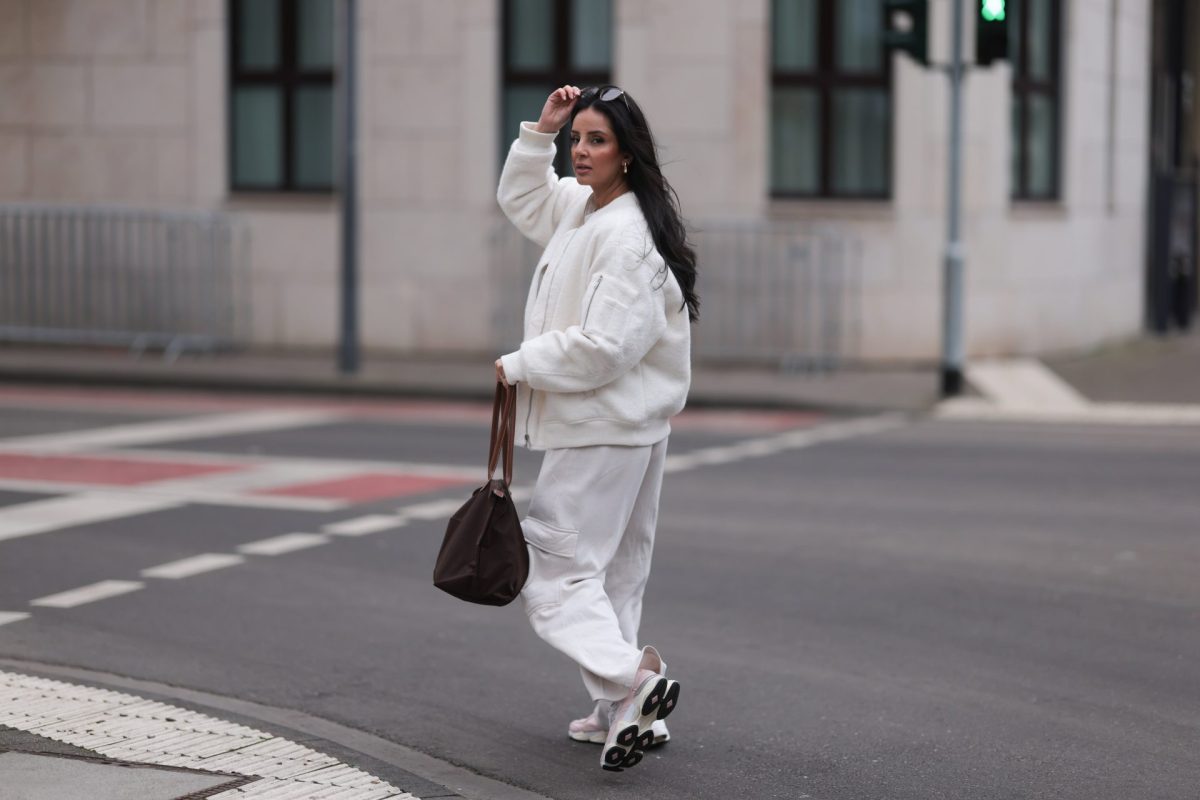 Frau im weißen Outfit mit Sneakern