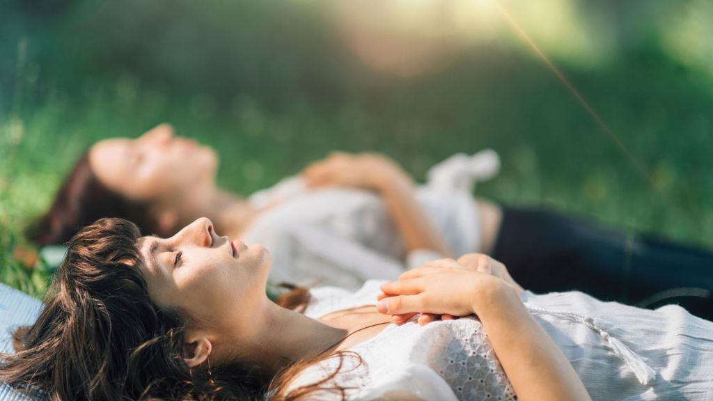 Frauen meditieren im liegen
