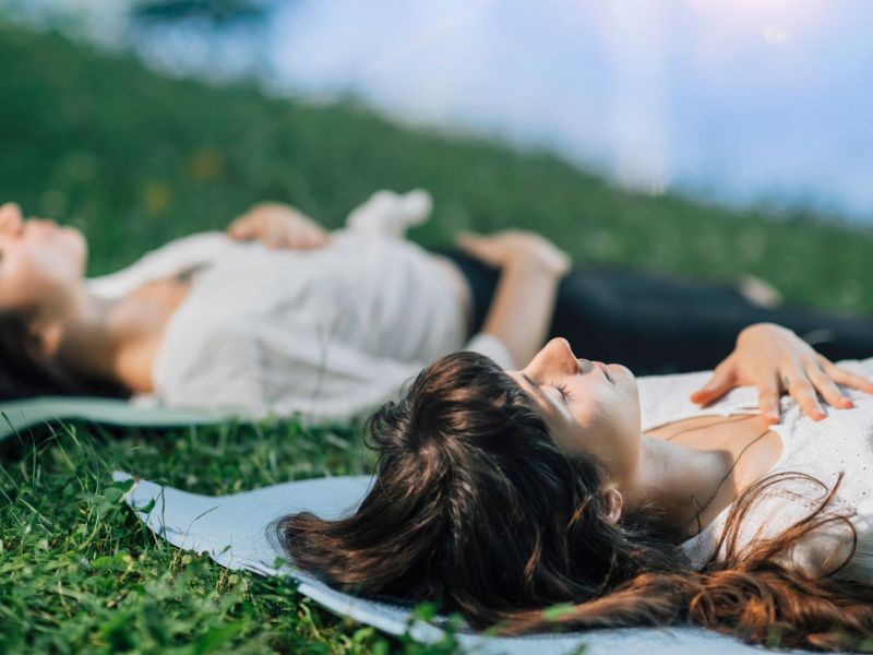 Frauen meditieren im Liegen