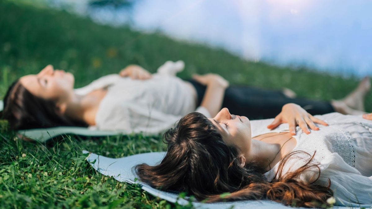 Frauen meditieren im Liegen