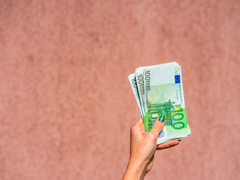 Hand, die Euro-Scheine hält.