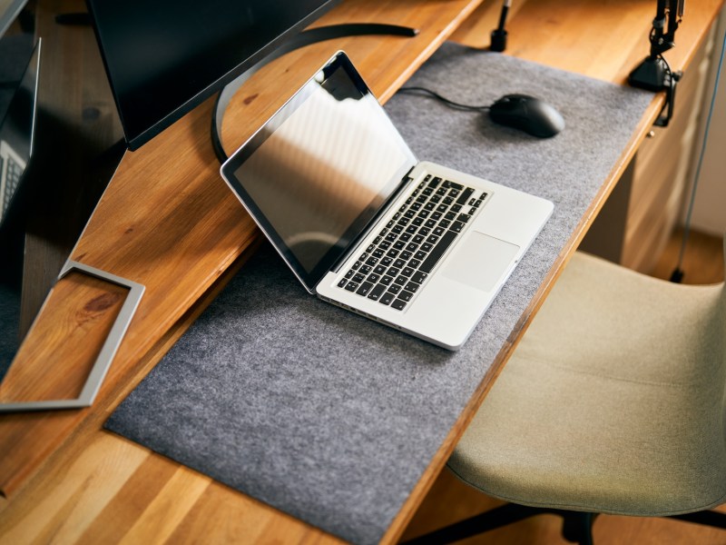 Draufsicht auf einen modernen Home-Office-Schreibtisch mit Laptop.