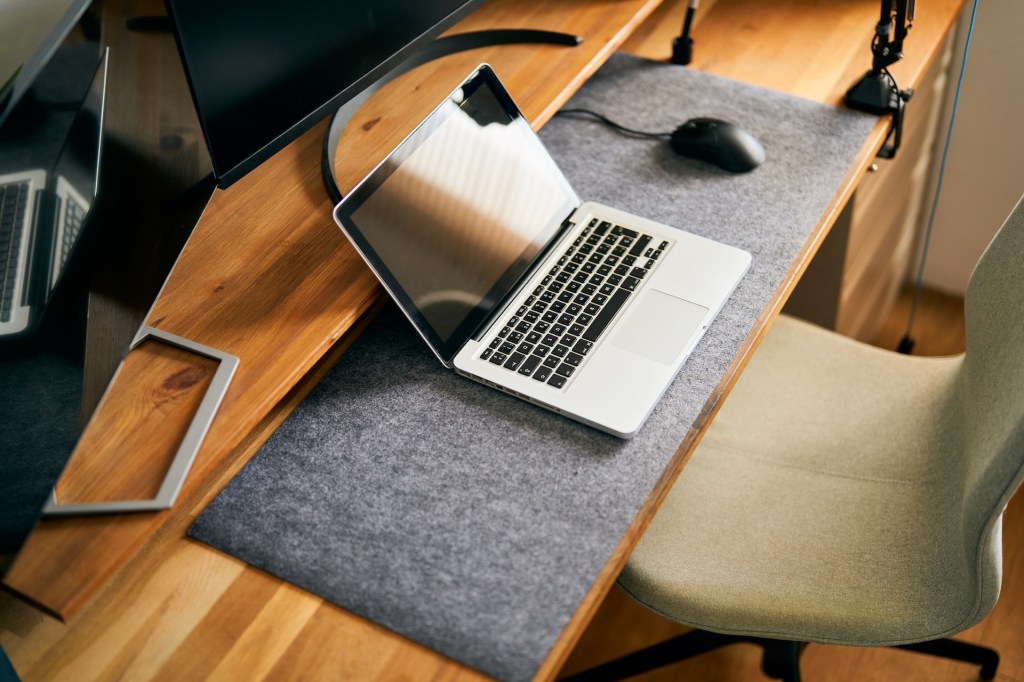 Draufsicht auf einen modernen Home-Office-Schreibtisch mit Laptop.