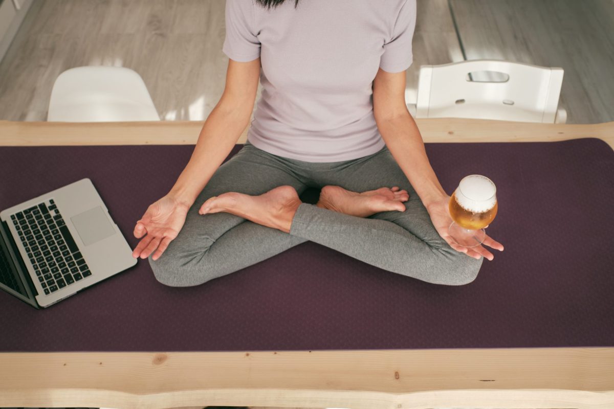 Frau macht Yoga mit Bier