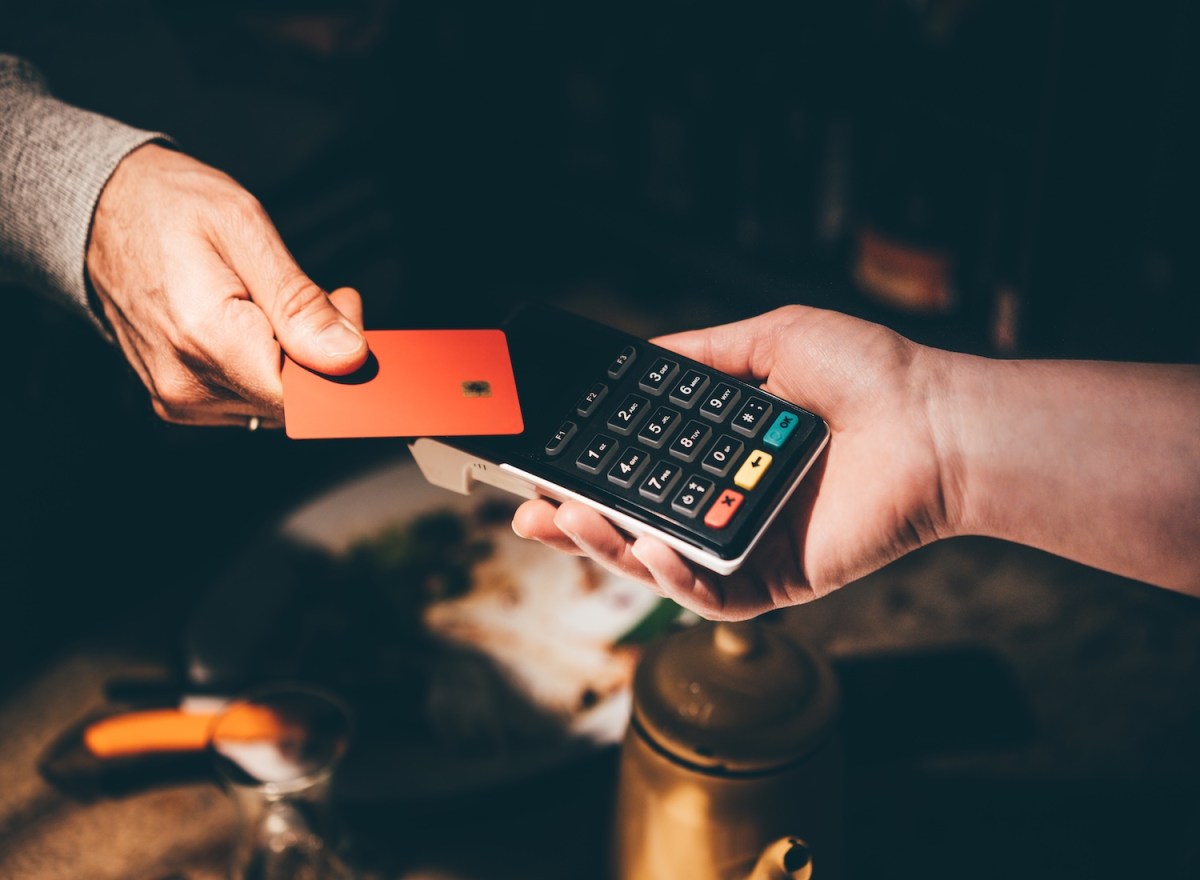 Eine Frau zahlt mit EC-Karte.