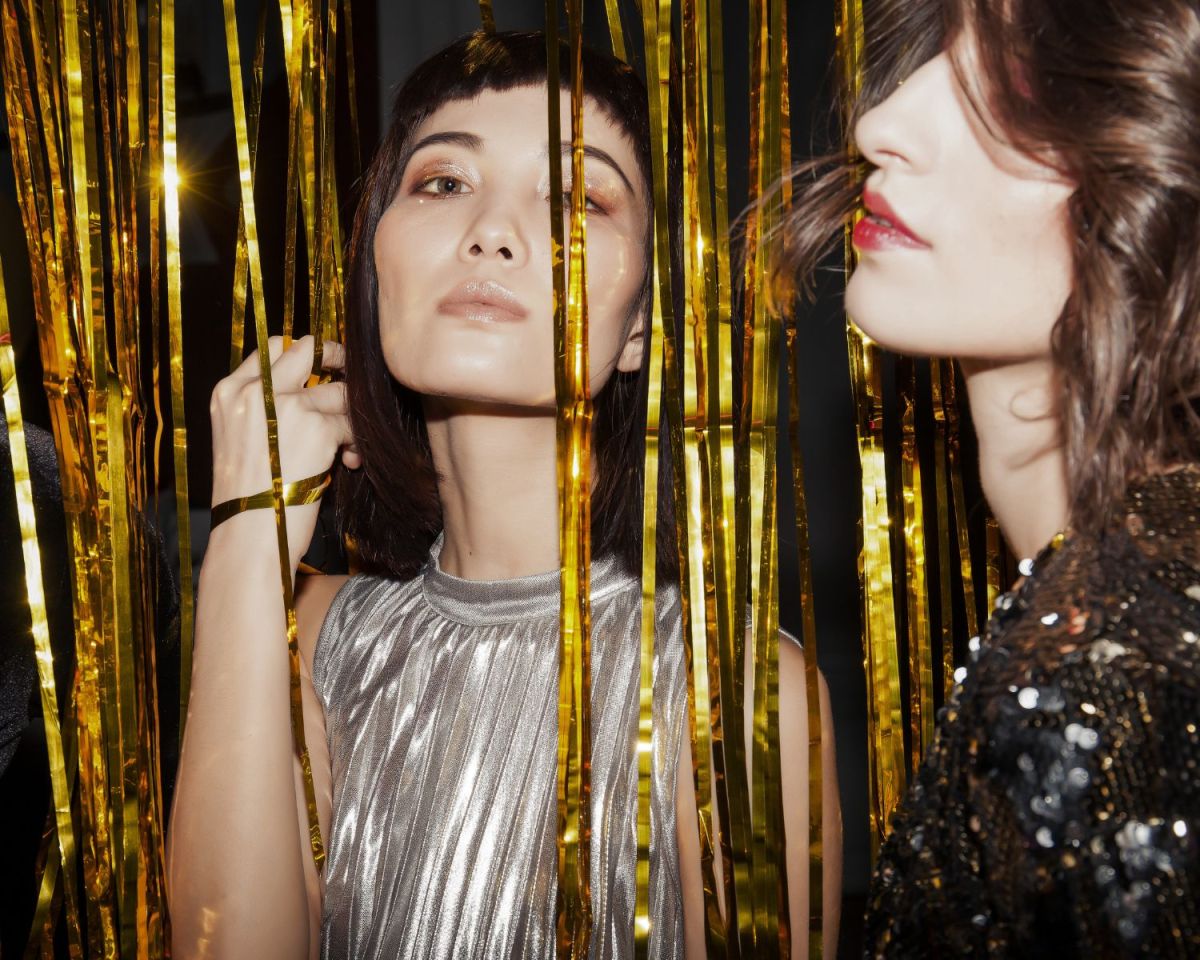 Frauen vor und hinter einem Lametta-Vorhang