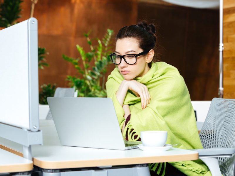 Frau friert im Büro