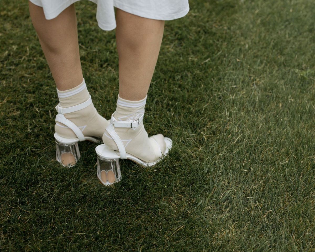 Frau mit Absatzschuhen auf grünem Rasen